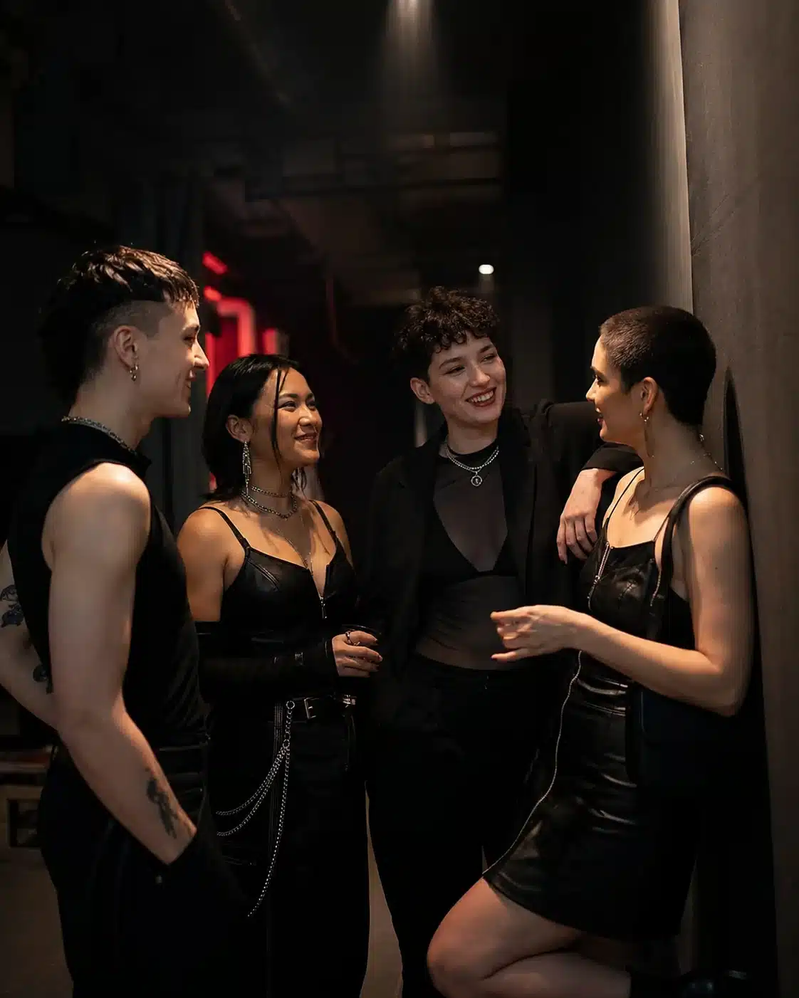 Charla y escucha en una comunidad nocturna Personas conversan en un club nocturno con estética leather